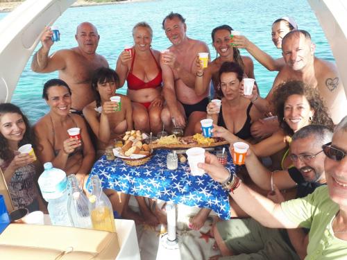 Group aboard a dinghy during aperitif in the Gulf of Asinara