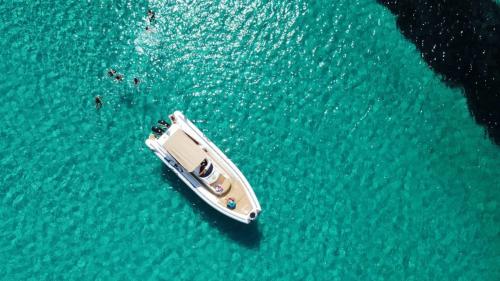 <p>Schlauchboot und Wanderer im türkisfarbenen Wasser der Insel Asinara</p><p><br></p>
