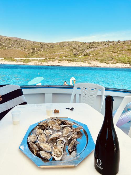 Aperitif mit Fisch und Wein an Bord eines Fischerbootes im Golf von Asinara