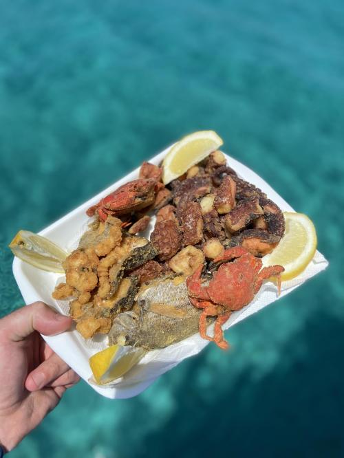 Dish with mixed fried food and blue sea