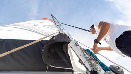 Comandante del catamarano issa la vela