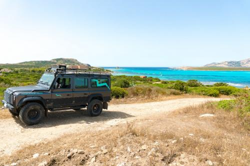 Off-road vehicle with La Pelosa beach in the background