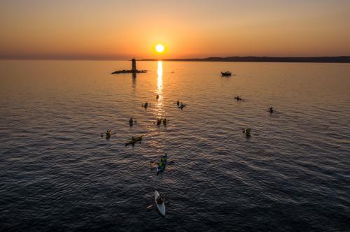 Faro al tramonto durante escursione in kayak a Sant'Antioco