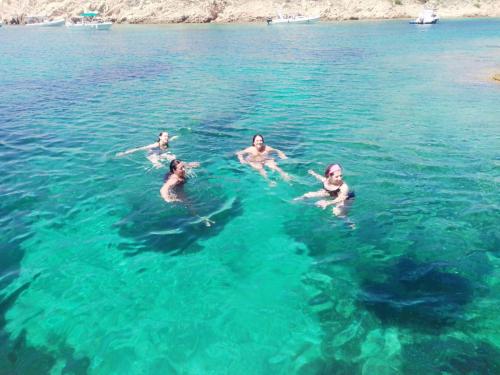 Wandergruppe badet im kristallklaren Wasser von La Maddalena