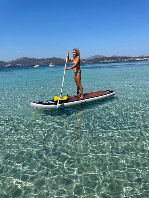 Fille dans la mer de la Costa Smeralda en SUP