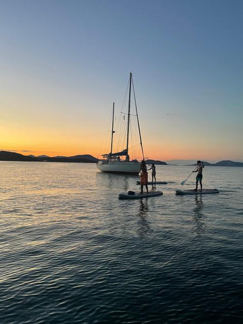 friends on a SUP excursion at sunset in the sea of the Costa Smeralda