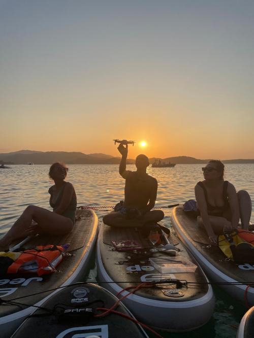 friends on a SUP excursion at sunset in the sea of the Costa Smeralda