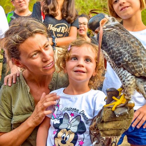 Mama und Tochter bewundern einen Falken aus nächster Nähe