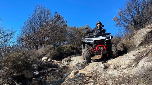 Woman driving quad on a rocky trail