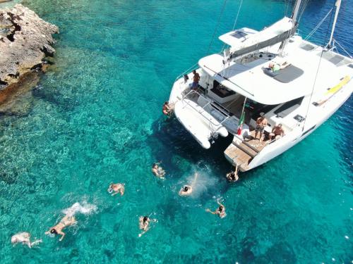 <p>Gruppo di persone tuffa dal catamarano</p><p><br></p>
