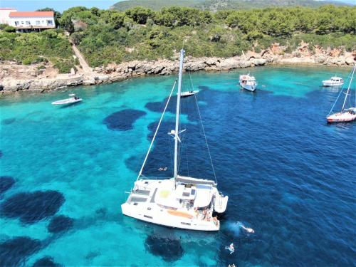 Golf von Alghero, Katamaran und türkisfarbenes Meer während der täglichen Tour mit Mittagessen