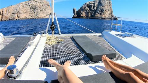 Ragazze prendono il sole a bordo di un catamarano ad Alghero