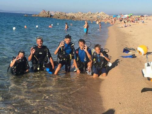 Gruppo di ragazzi in spiaggia durante escursione di battesimo subacqueo