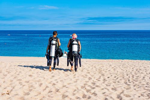 Par de excursionistas en la playa listos para la primera inmersión con equipo