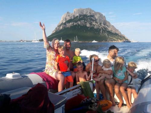 Family with children in a rubber dinghy in front of Tavolara