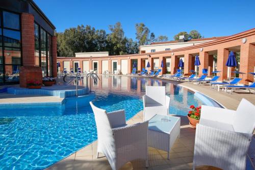Outdoor pool at the spa of Sardara and tables with chairs