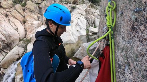 Une jeune fille installe une corde de rappel à Bau Mela