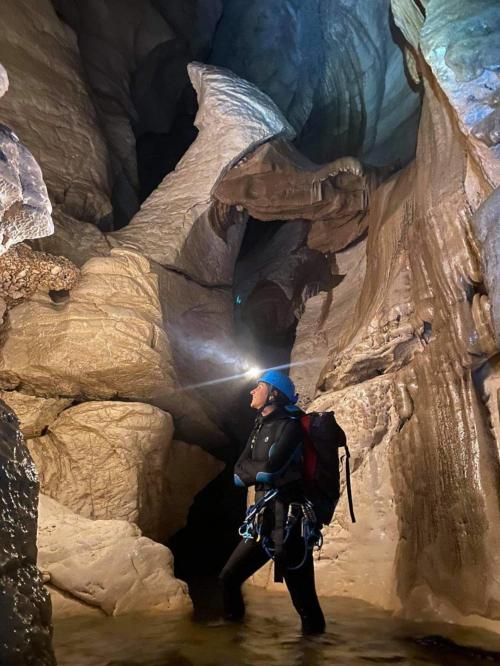 Escursionista all'interno della Grotta Donini illuminata solo da una torcia