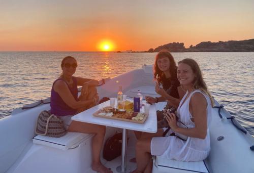 Escursionisti in gommone durante aperitivo a tramonto sul mare