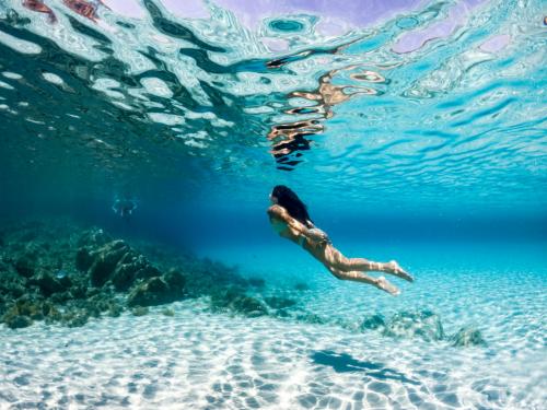 Girl swims in the blue sea of La Maddalena Archipel