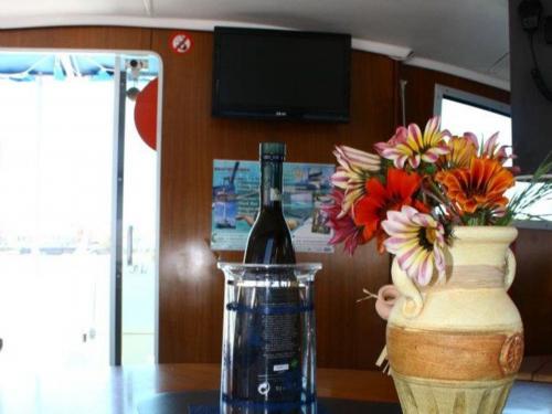 Bottiglia di vino e vaso negli interni di un catamarano a Cannigione