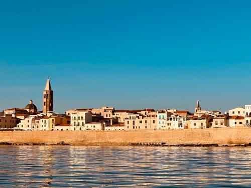 <p>Stadt Alghero bei Sonnenuntergang Blick von einem Segelboot</p><p><br></p>