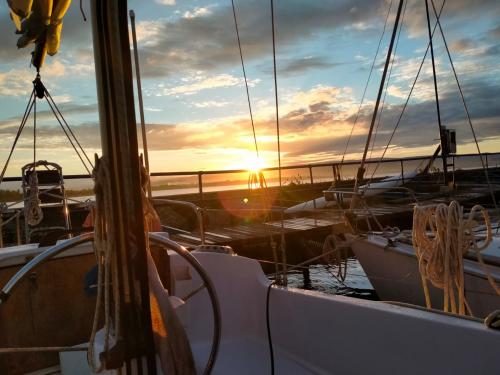 <p>Segelboot im Hafen von Alghero bei Sonnenuntergang</p>