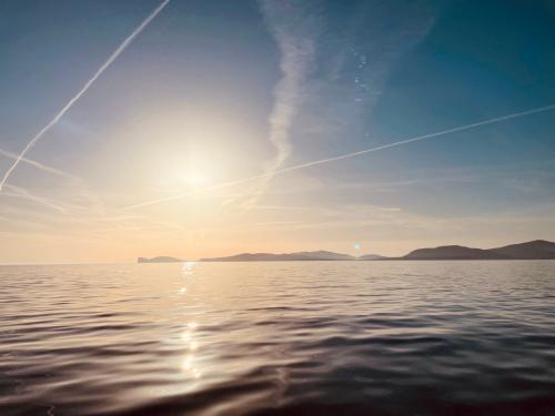 Tramonto su Capo Caccia visto da una barca a vela nel Golfo di Alghero