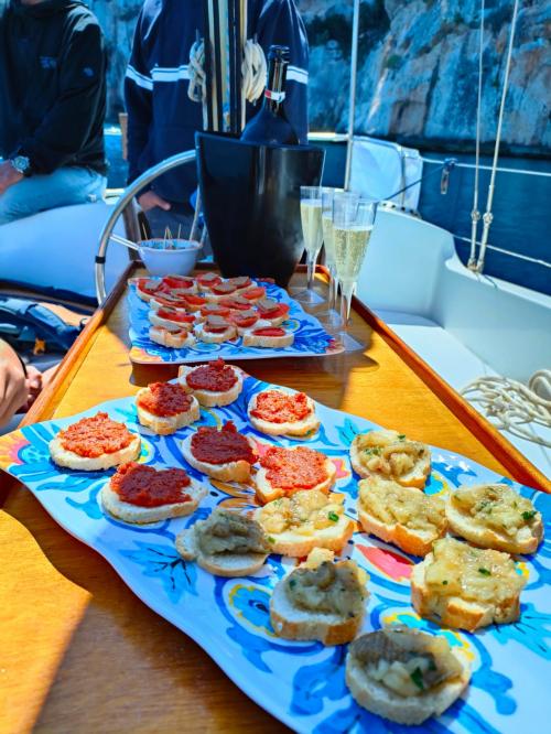 Aperitivo servito a bordo di una barca a vela nel Golfo di Alghero