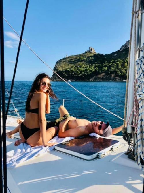 Couple of boys relax aboard a sailboat in the Gulf of Cagliari