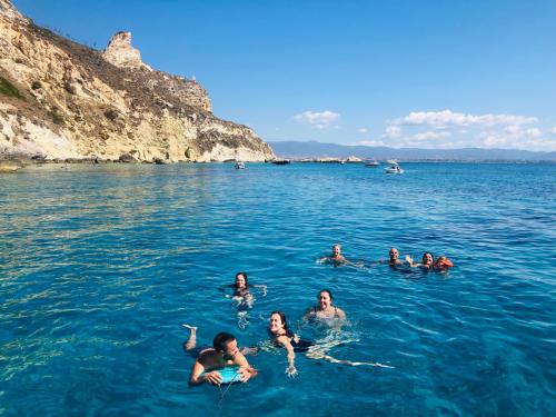 Hikers swim in the crystal clear sea of the Gulf of Cagliari during sailing tour