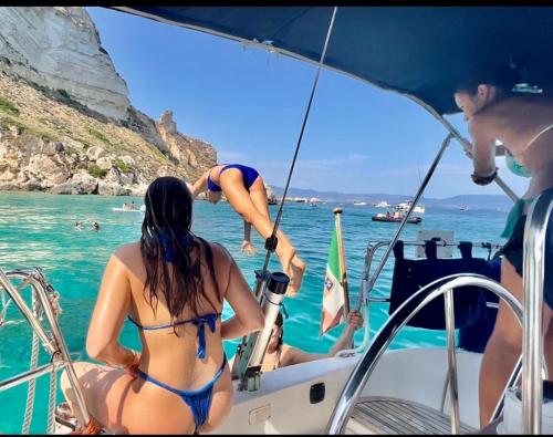 Mädchen und Tauchen von einem Segelboot in Cagliari