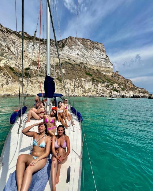 Girls enjoy the sun aboard a sailboat in Cagliari