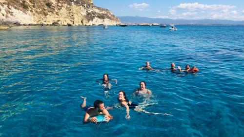 Escursionisti nuotano nel mare cristallino del Golfo di Cagliari tour in barca a vela