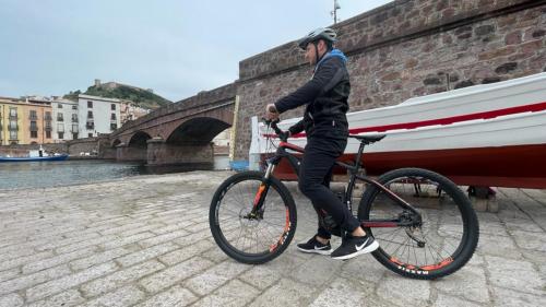 Ein Mann erkundet Bosa mit dem E-Bike