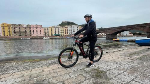 Ein Mann erkundet Bosa mit dem E-Bike