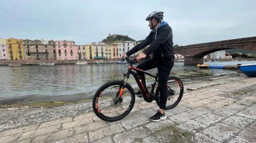 Ein Mann erkundet Bosa mit dem E-Bike