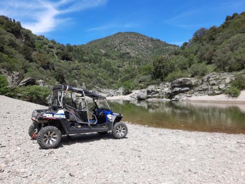 quad polaris davanti a un ago di montagna nel Gennargentu