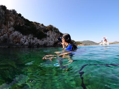 Mädchen badet im Golf von Alghero während eines Bootsausflugs