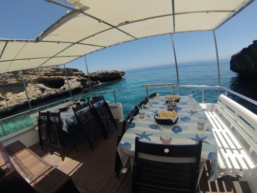 <p>Tische an Bord eines Motorbootes zum Mittagessen während des Tagesausflugs von Alghero</p>