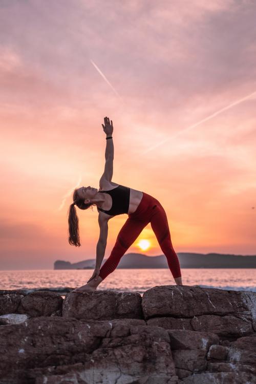 <p>Yogalehrer bei Sonnenuntergang in Alghero mit Capo Caccia im Hintergrund</p><p><br></p>