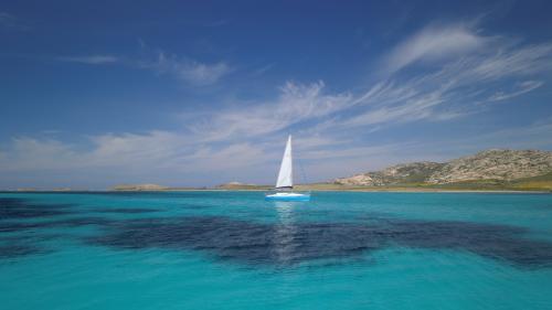 Barca a vela in lontananza nel Golfo dell'Asinara
