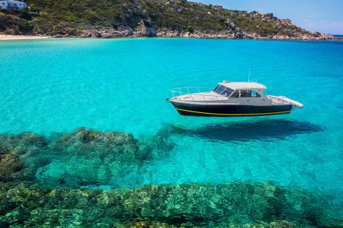 <p>Motorboot segelt im türkisfarbenen Meer im Süden Korsikas während der täglichen Tour</p><p><br></p>