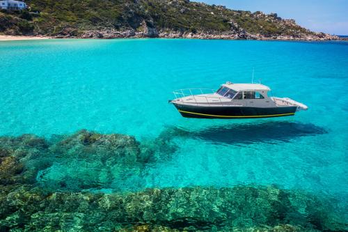 <p>Bateau à moteur naviguant dans la mer turquoise du sud de la Corse pendant le tour quotidien</p><p><br></p>