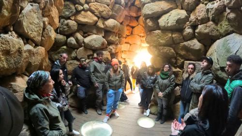 Groupe de personnes avec guide à l'intérieur d'un nuraghe en Gallura 