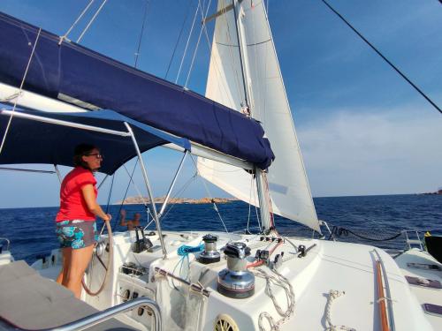 Skipper in navigazione a bordo catamarano in Sardegna