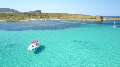 Barca a motore vicino torretta d'avvistamento nel Golfo dell'Asinara