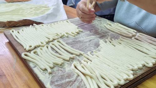 Making fresh pasta during a traditional cooking workshop in Bosa