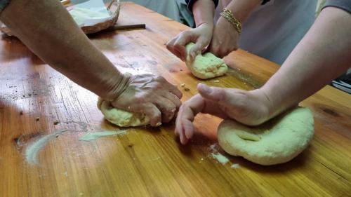 Partecipanti al laboratorio lavorano la pasta fresca