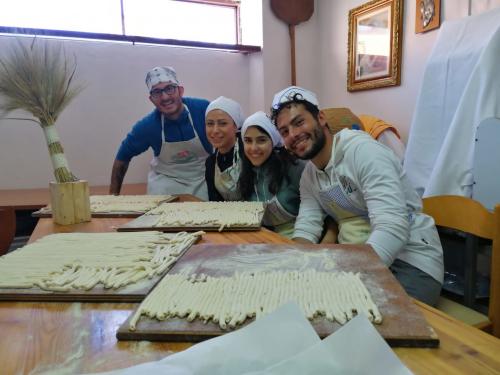 group of tourists prepare fresh pasta in Bosa